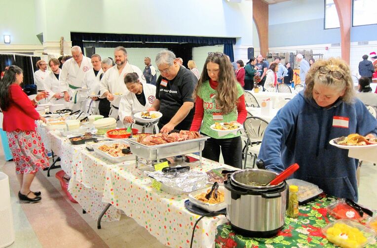 ３年ぶりの屋内開催となった忘年会で料理を楽しむ県人関係者ら＝アトランタ市内