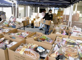 無料配布する食料や日用品を準備する非営利団体のスタッフ＝２１日、米ロサンゼルス（共同）