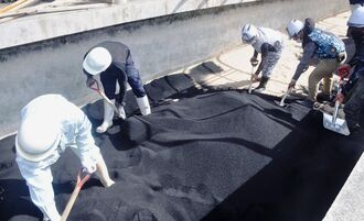 ＰＦＡＳ除去のため、金武浄水場に活性炭を入れる作業員＝５月、金武町