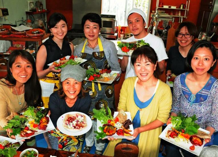宮古島産野菜を使った料理をする小原千嘉子さん（前列左から２人目）と受講者＝市平良下里の島野菜デリ「じゃからんだ」