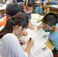沖縄戦の証言を読んで、避難ルートを地図に書き込む児童たち＝２２日、南風原小学校