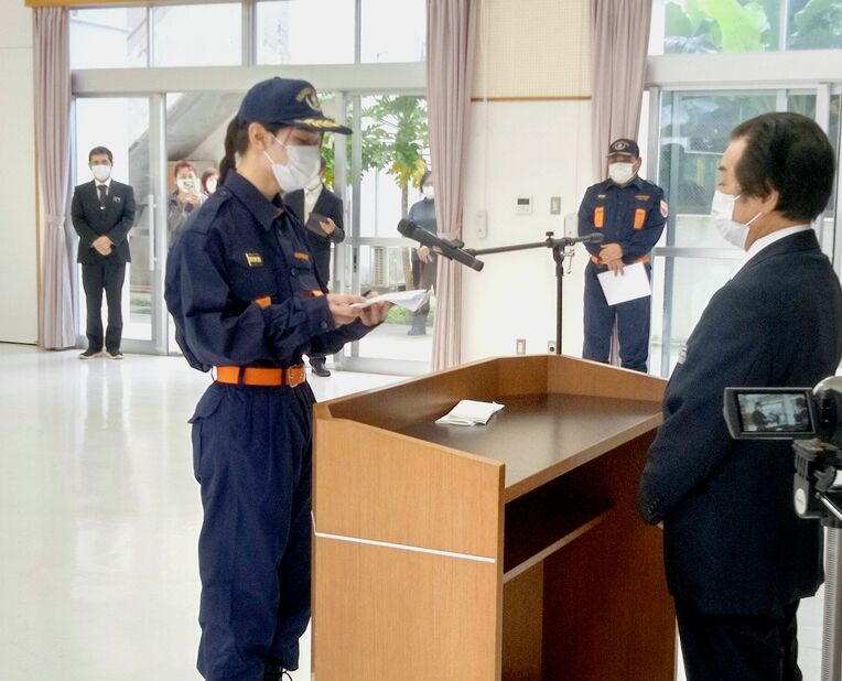 決意表明する一日消防団長の高江洲一平さん（左）＝６日、多良間村コミュニティー施設