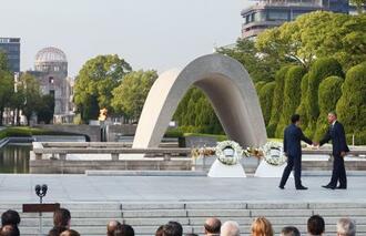 　２０１６年５月、原爆慰霊碑に献花を終え、安倍首相（左）と握手するオバマ米大統領＝広島市の平和記念公園