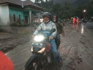 　４日、インドネシア・ジャワ島の東ジャワ州でバイクに乗って噴火から避難する人（国営アンタラ通信提供、ロイター＝共同）