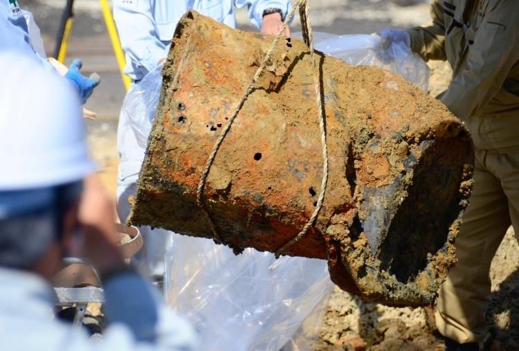 新たに見つかったドラム缶の一つ。調査員がビニール袋に入れ、サンプルを採取した＝２９日午後１時５０分ごろ、沖縄市上地・市サッカー場