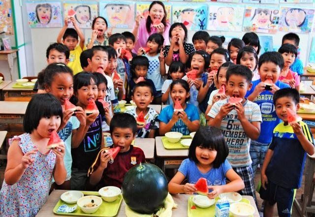 「みずみずしくて甘ーい」。読谷産の黒玉スイカをおいしそうに食べる２年２組の子どもたち＝６月３０日、読谷村・喜名小学校