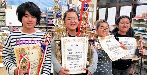 全国大会で３冠を獲得した長義絵里以さん（左から２人目）と上位に入った生徒たち＝沖縄市泡瀬・あわせそろばん教室