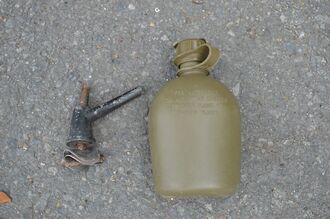米軍が車両から落下させた水筒と金属製の部品=11日午後0時半ごろ、東村慶佐次
